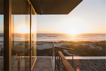 View of sunset over ocean from balcony of modern house Photographie de stock - Premium Libres de Droits, Code: 6113-07160187