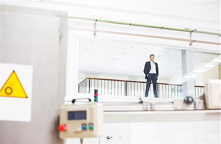 people working in factory - Businessman looking out observation window in factory Stock Photo - Premium Royalty-Free, Code: 6113-07160277