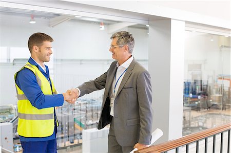 Supervisor and worker shaking hands in factory Stock Photo - Premium Royalty-Free, Code: 6113-07160287