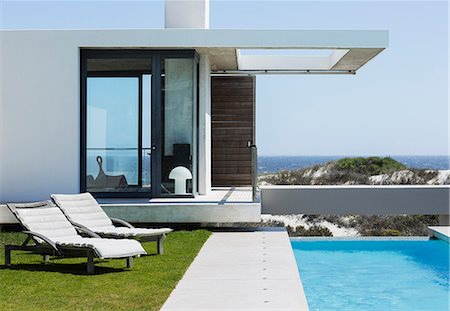 simsearch:6113-07159869,k - Lounge chairs and lap pool outside modern house overlooking ocean Stock Photo - Premium Royalty-Free, Code: 6113-07160202