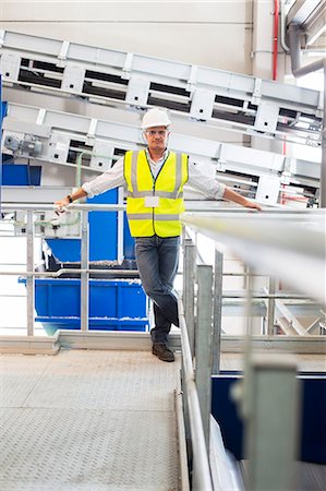 simsearch:6113-07160283,k - Worker leaning on platform railing in factory Stock Photo - Premium Royalty-Free, Code: 6113-07160311