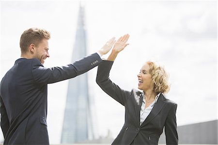 simsearch:6113-07648679,k - Business people high fiving outdoors Stock Photo - Premium Royalty-Free, Code: 6113-07160450