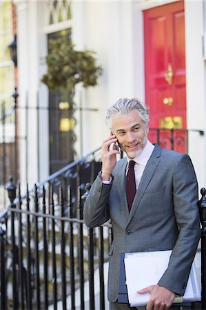 front stoop - Businessman talking on cell phone on front stoop Stock Photo - Premium Royalty-Free, Code: 6113-07160641