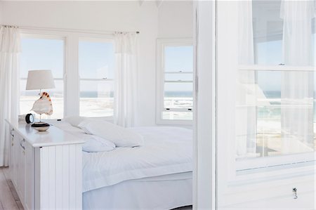 simsearch:6113-07159869,k - White bedroom overlooking ocean Stock Photo - Premium Royalty-Free, Code: 6113-07160821