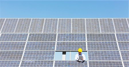 Scientist examining solar panel in rural landscape Photographie de stock - Premium Libres de Droits, Code: 6113-07160929