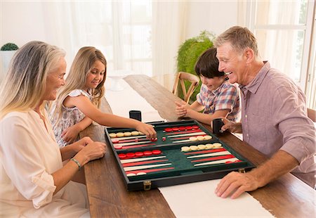 family life grandparent - Grandparents and grandchildren playing backgammon Stock Photo - Premium Royalty-Free, Code: 6113-07241999