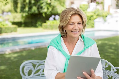 Senior woman using digital tablet in backyard Stock Photo - Premium Royalty-Free, Code: 6113-07242044