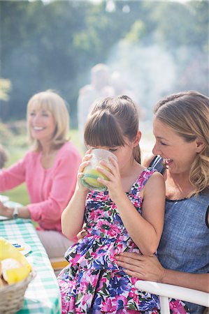 simsearch:6113-07242309,k - Girl drinking juice on mother's lap in backyard Stock Photo - Premium Royalty-Free, Code: 6113-07242384