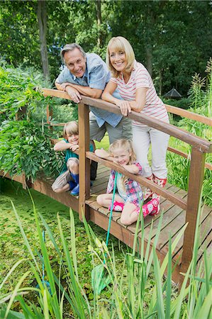 portrait of boy with arms crossed - Grandparents and grandchildren smiling on wooden footbridge Stock Photo - Premium Royalty-Free, Code: 6113-07242325