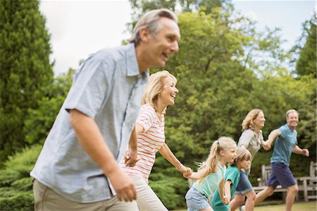family playing outside - Multi-generation family holding hands and running Stock Photo - Premium Royalty-Free, Code: 6113-07242451