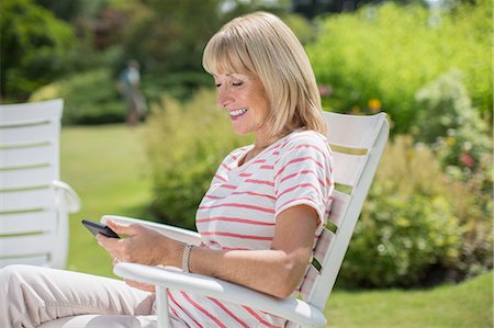 Woman using cell phone in garden Stock Photo - Premium Royalty-Free, Code: 6113-07242452