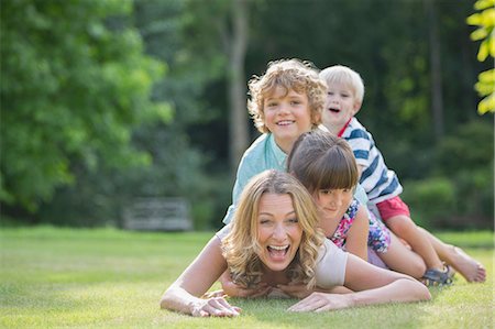 Children laying on mother in grass Foto de stock - Sin royalties Premium, Código: 6113-07242464