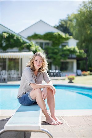 diving board - Woman sitting on diving board at poolside Stock Photo - Premium Royalty-Free, Code: 6113-07242481