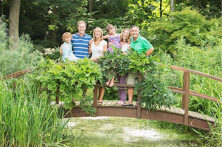 simsearch:6113-07242393,k - Multi-generation family standing on wooden footbridge over pond Stock Photo - Premium Royalty-Free, Code: 6113-07242404