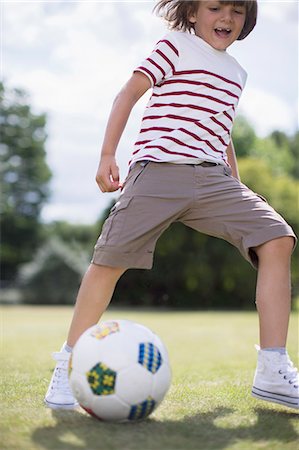 Boy playing soccer outdoors Stock Photo - Premium Royalty-Free, Code: 6113-07242433