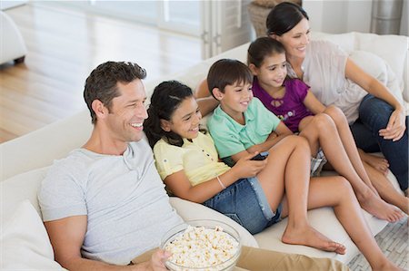 simsearch:6113-07242497,k - Family watching TV on sofa in living room Foto de stock - Sin royalties Premium, Código: 6113-07242596