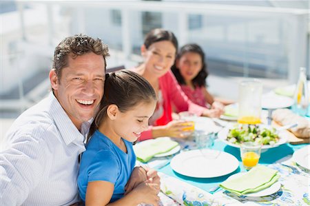 simsearch:6113-07242497,k - Family eating lunch at table on sunny patio Foto de stock - Sin royalties Premium, Código: 6113-07242531