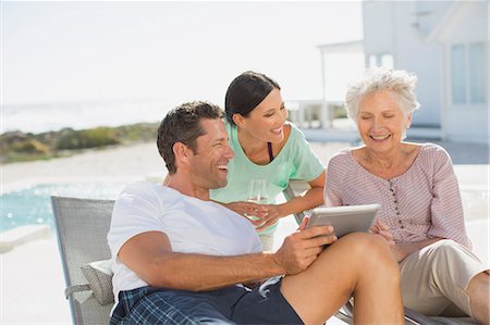 simsearch:6113-06720636,k - Family using digital tablet at poolside Stock Photo - Premium Royalty-Free, Code: 6113-07242538