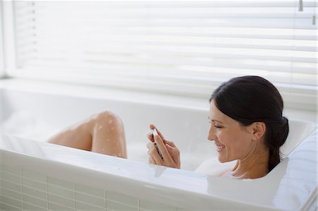 Woman using cell phone in bubble bath Foto de stock - Sin royalties Premium, Código: 6113-07242647