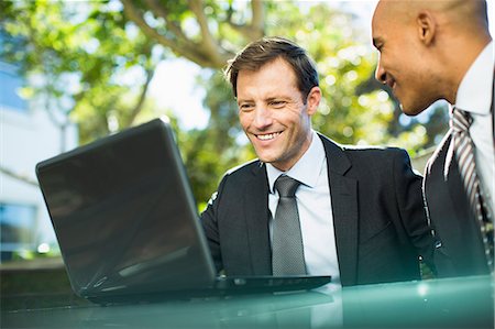 Businessmen using laptop outdoors Stock Photo - Premium Royalty-Free, Code: 6113-07242686