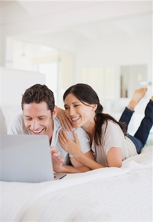 Couple using laptop on bed Stock Photo - Premium Royalty-Free, Code: 6113-07242638