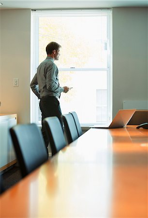 simsearch:6113-06753440,k - Businessman standing at conference room window Stock Photo - Premium Royalty-Free, Code: 6113-07242712