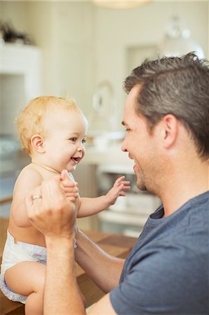 simsearch:6113-07543205,k - Father and baby laughing in kitchen Stock Photo - Premium Royalty-Free, Code: 6113-07242858