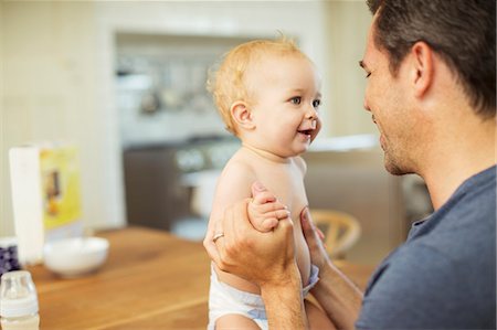 simsearch:6113-07543205,k - Father holding baby in kitchen Stock Photo - Premium Royalty-Free, Code: 6113-07242866