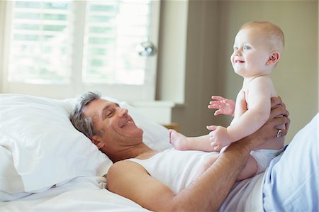 Father playing with baby on bed Foto de stock - Sin royalties Premium, Código: 6113-07242894