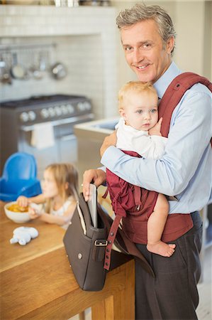 Businessman carrying baby in kitchen Photographie de stock - Premium Libres de Droits, Code: 6113-07242804