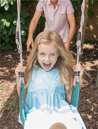 swing - Father pushing daughter in swing Stock Photo - Premium Royalty-Free, Code: 6113-07242955