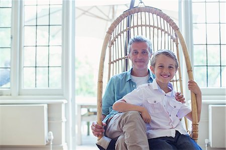 simsearch:6113-06626289,k - Father and son sitting in wicker chair Stock Photo - Premium Royalty-Free, Code: 6113-07242959