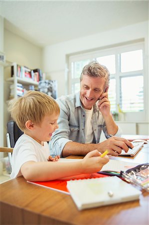 father holding his son - Father and son working in home office Stock Photo - Premium Royalty-Free, Code: 6113-07242977