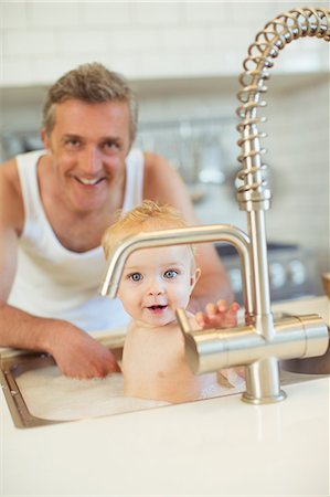 Father bathing baby in kitchen sink Stock Photo - Premium Royalty-Free, Code: 6113-07242906