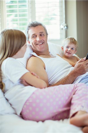 pyjamas (sleepwear with pants) - Father and children relaxing on bed Stock Photo - Premium Royalty-Free, Code: 6113-07242917