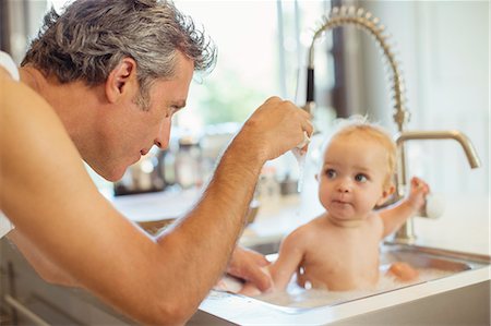 saturated - Father bathing baby in kitchen sink Stock Photo - Premium Royalty-Free, Code: 6113-07242915