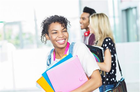 Smiling university student carrying folders Stock Photo - Premium Royalty-Free, Code: 6113-07243420