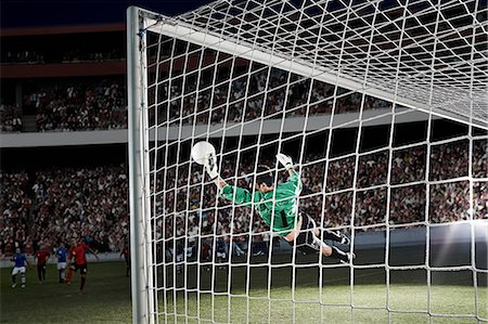 stadium with people outdoor football - Goalie defending soccer net on field Stock Photo - Premium Royalty-Free, Code: 6113-07310548