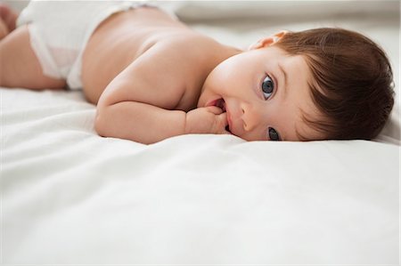 Baby girl laying on bed Stock Photo - Premium Royalty-Free, Code: 6113-07542379