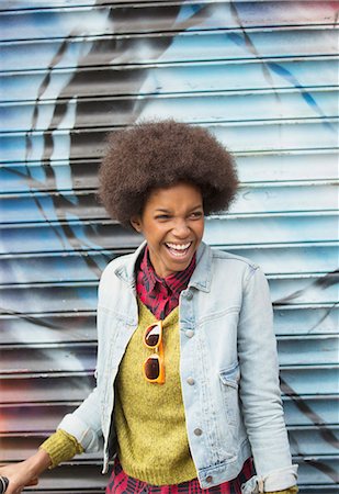 Woman laughing in front of graffiti wall Stock Photo - Premium Royalty-Free, Code: 6113-07542424