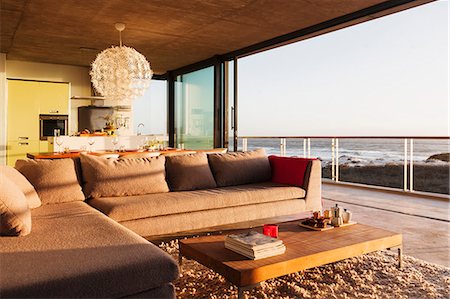 simsearch:6113-07542742,k - Sofa and coffee table in modern living room overlooking ocean Stock Photo - Premium Royalty-Free, Code: 6113-07542778