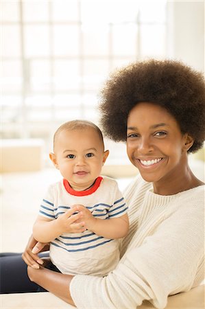 simsearch:6113-07543258,k - Mother holding baby boy on sofa Photographie de stock - Premium Libres de Droits, Code: 6113-07542838