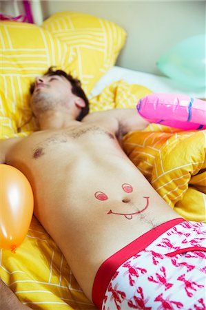 funny man - Man with smiley face drawing on belly sleeping after party Stock Photo - Premium Royalty-Free, Code: 6113-07542978