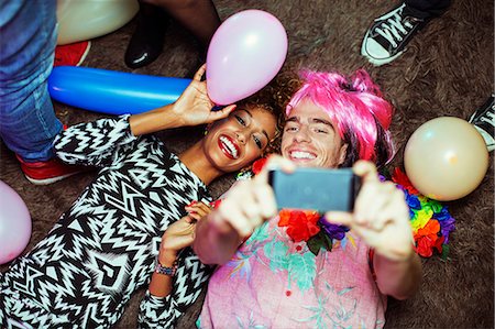 selfie - Couple taking self-portrait with cell phone on floor at party Stock Photo - Premium Royalty-Free, Code: 6113-07543055