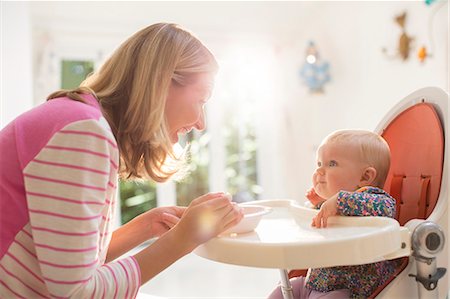 simsearch:6113-07543258,k - Mother feeding baby girl in high chair Photographie de stock - Premium Libres de Droits, Code: 6113-07543150