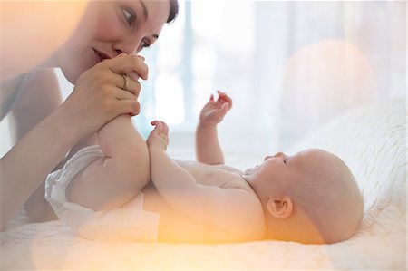 Mother kissing baby girl's feet Photographie de stock - Premium Libres de Droits, Code: 6113-07543179