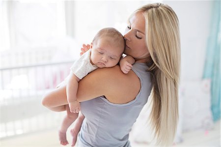 daughter kissing mother - Mother carrying sleeping baby girl Stock Photo - Premium Royalty-Free, Code: 6113-07543193