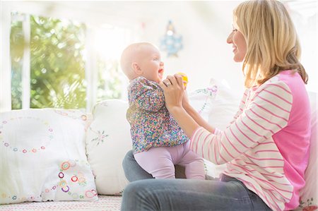 simsearch:6113-07543258,k - Mother playing with baby girl on sofa Photographie de stock - Premium Libres de Droits, Code: 6113-07543275