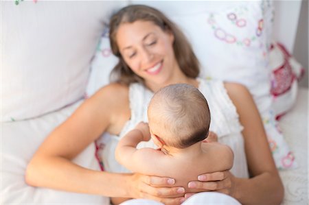 simsearch:6113-07543258,k - Mother holding baby boy on bed Photographie de stock - Premium Libres de Droits, Code: 6113-07543213