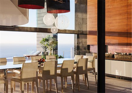 simsearch:6113-07542764,k - Table and chairs in modern dining room overlooking ocean Stock Photo - Premium Royalty-Free, Code: 6113-07543341